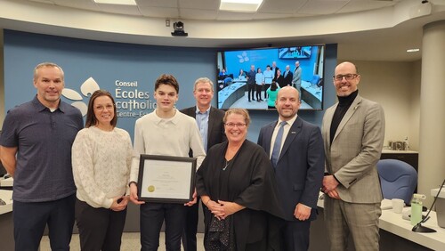 Maxime Cazabon tient son certificat entouré de 6 personnes lors d'une réunion du Conseil.