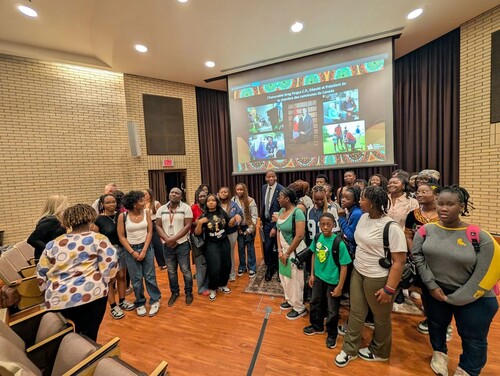 Groupe d’élèves rassemblés dans un auditorium devant un écran de présentation lors d’une rencontre éducative.