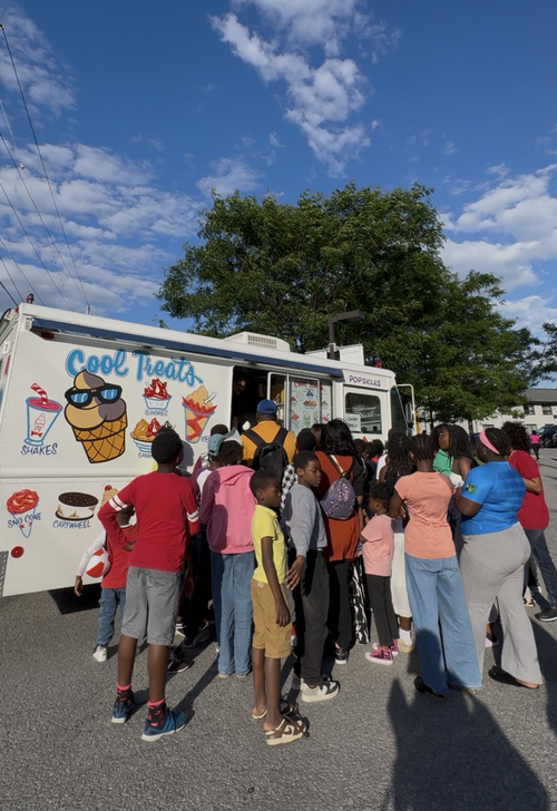 Des enfants font la file devant un camion de crème glacée.