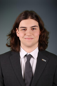 Portrait professionnel d’Olivier Gagnon Maheu souriant, vêtu d’un veston foncé et d’une chemise blanche avec cravate grise.