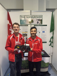 Stefan Teotorescu et Oscar Barbieri tiennet un robot nommé « The Mangrover » devant leur affiche de projet scientifique.