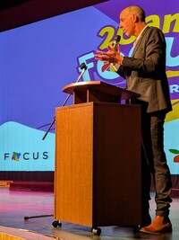 Jason Dupuis parle sur la scène de l'auditorium de l'École secondaire catholique Béatrice-Desloges