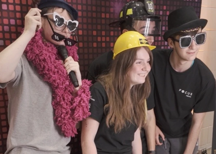 Élèves qui posent devant un photobooth déguisés dans des costumes qui représentent différents métiers