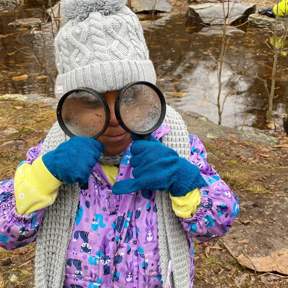 Élève à l'extérieur avec deux loupes sur les yeux en mode exploration