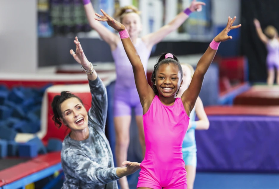Élèves de gymnastiques et leur enseignante souriant 