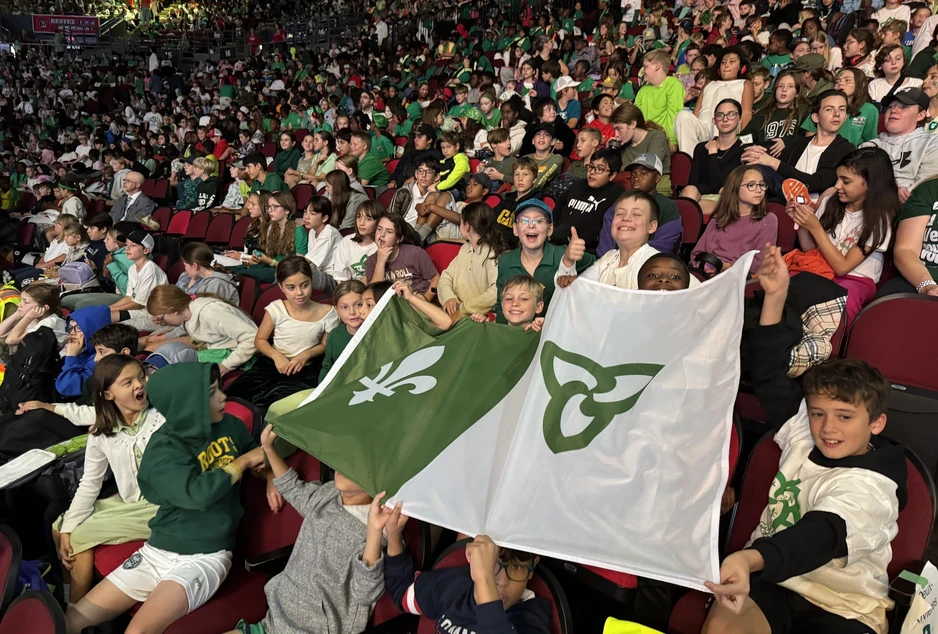 Une foule d'élèves du CECCE célèbre dans les gradins de la Place TD brandissant fièrement le drapeau franco-ontarien.