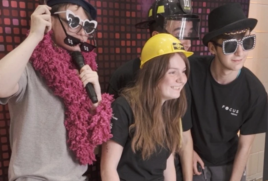 Élèves qui posent devant un photobooth déguisés dans des costumes qui représentent différents métiers