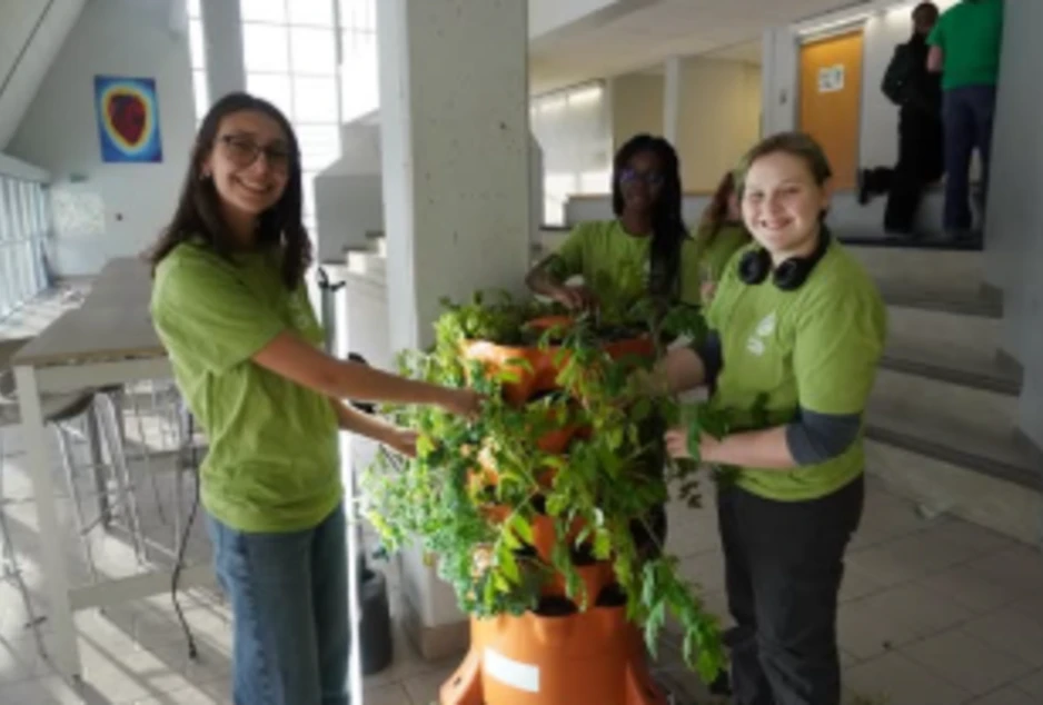 Des élèves devant une station de plantes vertes