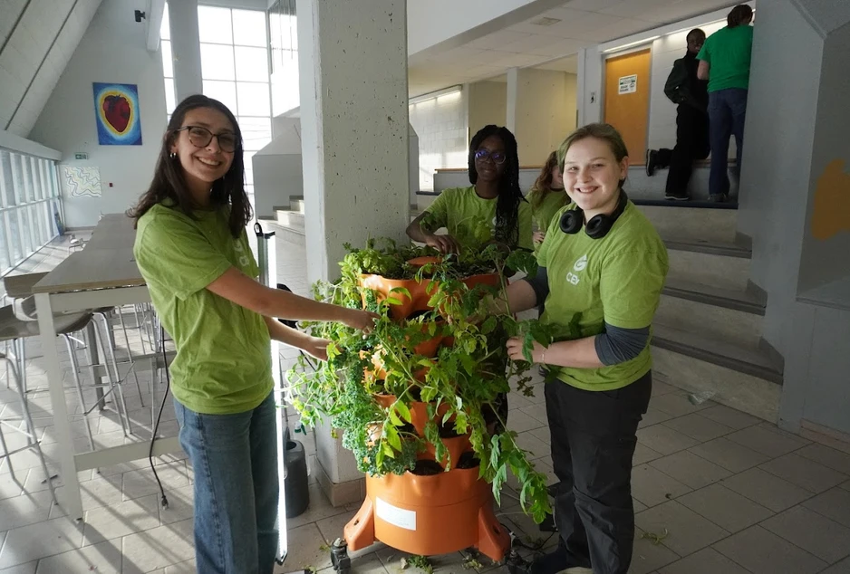 Des élèves devant une station de plantes vertes