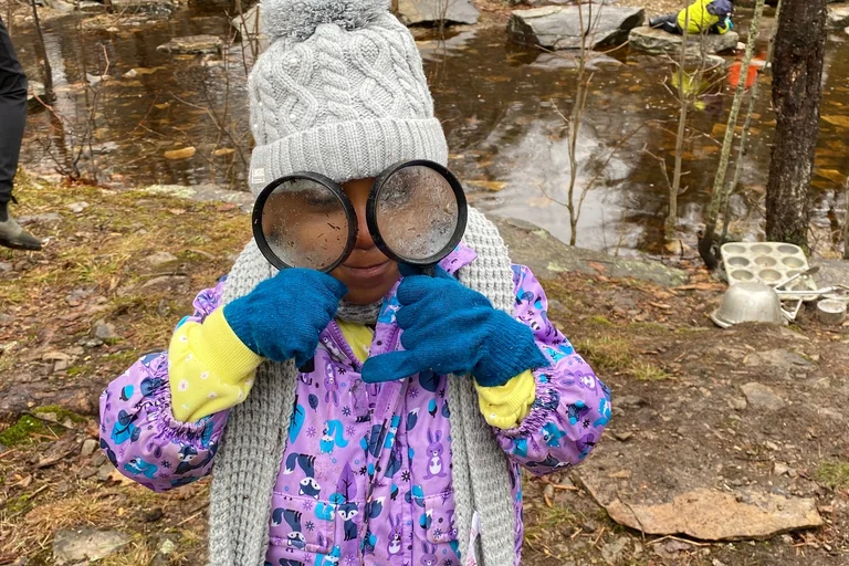 Élève en nature avec deux loupes sur les yeux