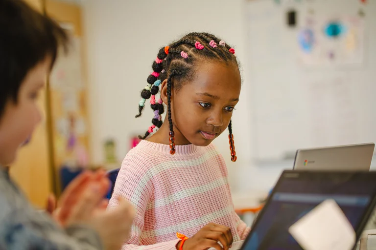 petite fille au chandail rose à l'ordinateur