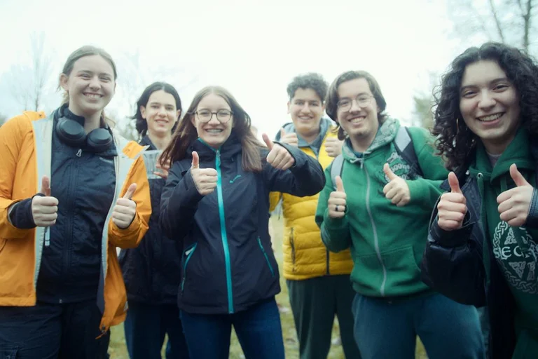 Groupe d’élèves souriants levant les pouces lors d’une activité extérieure