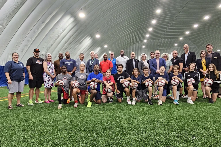 Groupe de personnes à l'inauguration d'un nouveau dôme sportif