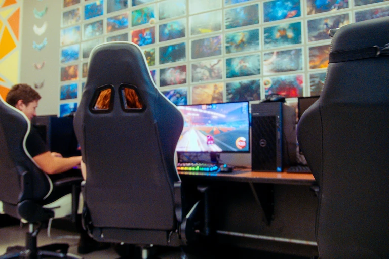 élèves assis sur des chaises de bureau qui jouent à l'ordinateur