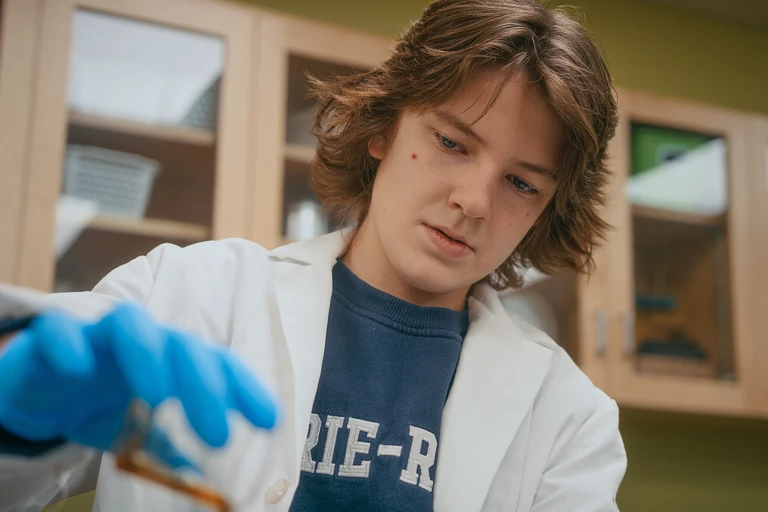 élève dans un local de science avec son équipement de protection