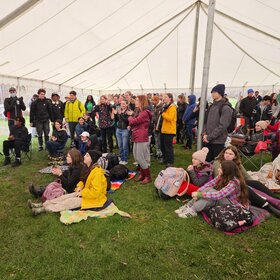 Groupe d’élèves et d’adultes réunis sous un grand chapiteau lors d’une activité scolaire